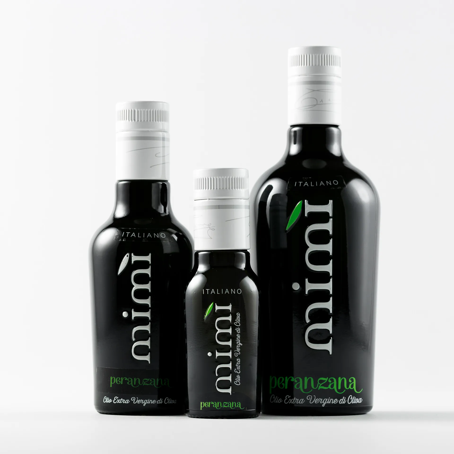 Tre bottiglie nere di olio extra vergine di oliva italiano Mimi Peranzana di varie dimensioni sono disposte in verticale su uno sfondo bianco.